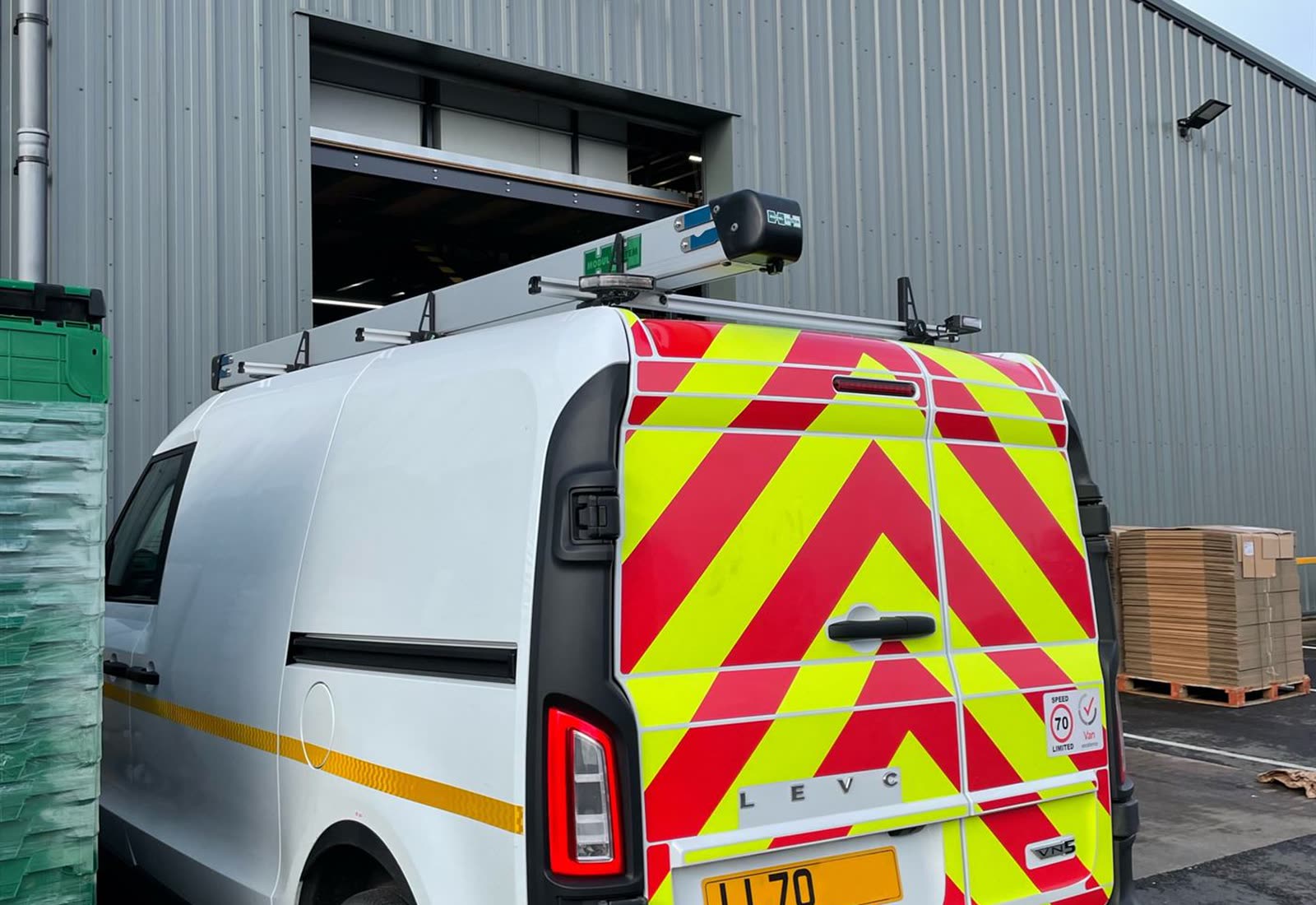 An electric collection van and stacked returns totes at the Greensafe loading bay