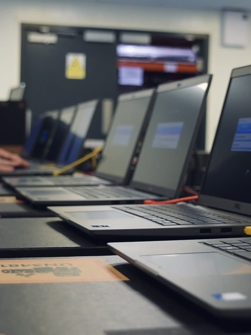 A line of laptops being imaged and configured at our configuration centre