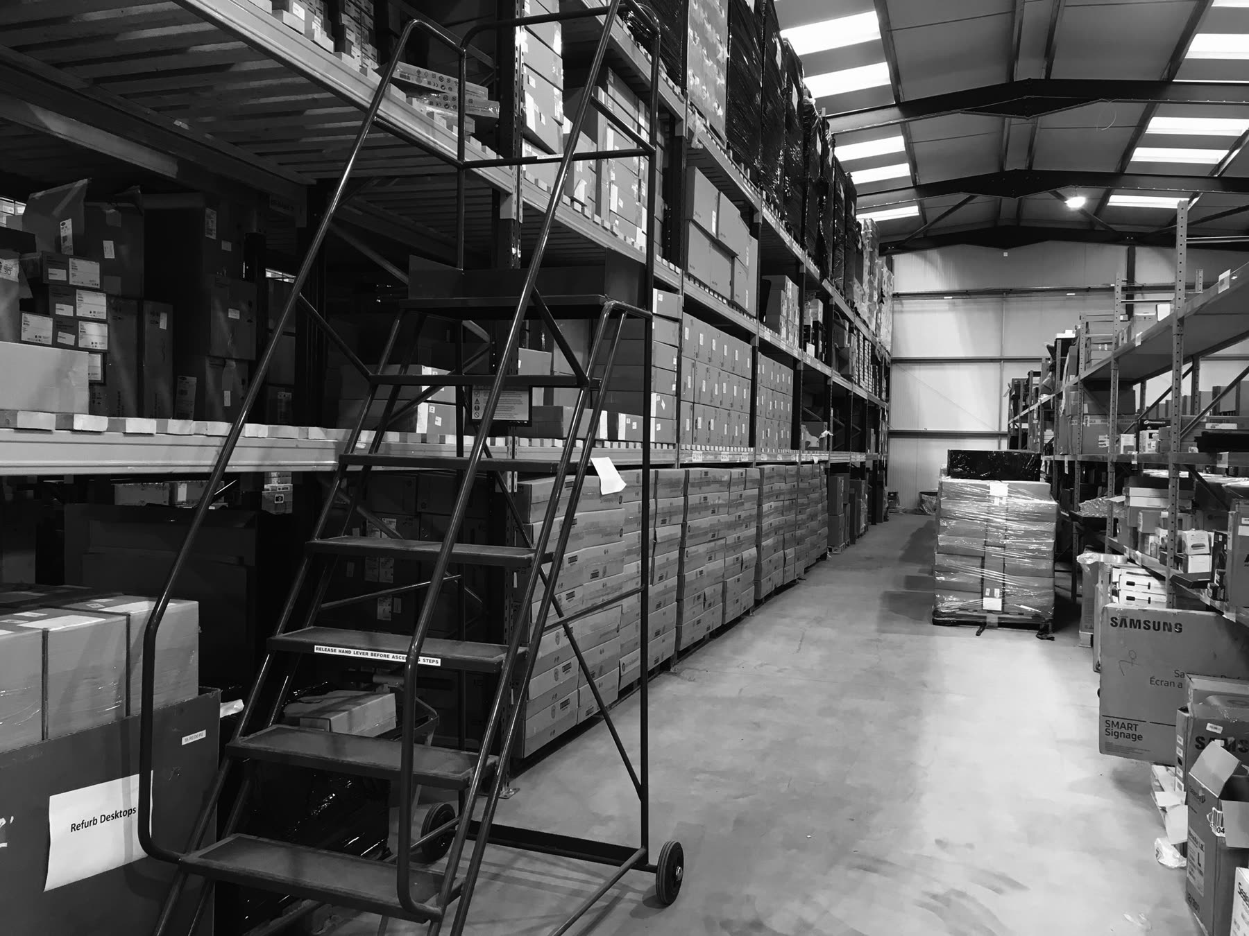 Racking bays inside the Greensafe warehouse stacked with boxed and palletised IT equipment