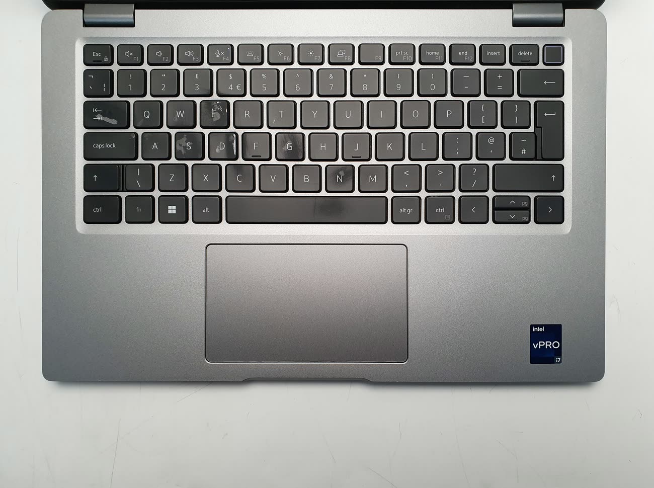 A worn laptop keyboard with shiny, marked keycaps