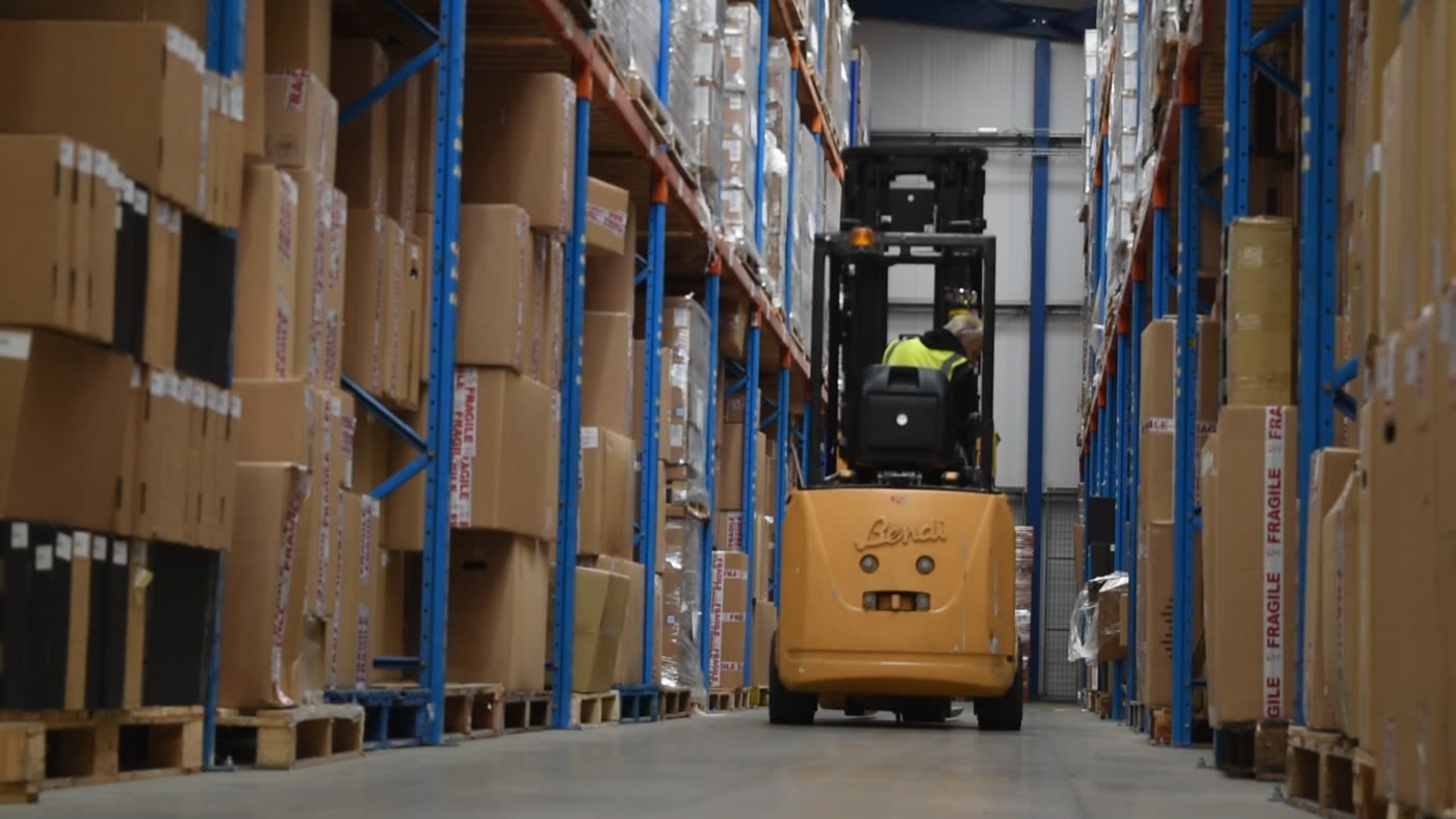 A bonded warehouse storage aisle, racking packed with palletised stock on both sides